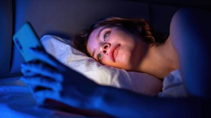 A woman anxiously waits for a goodnight text message before going to bed