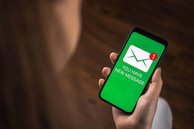 Une femme tenant un téléphone portable affichant un nouveau message