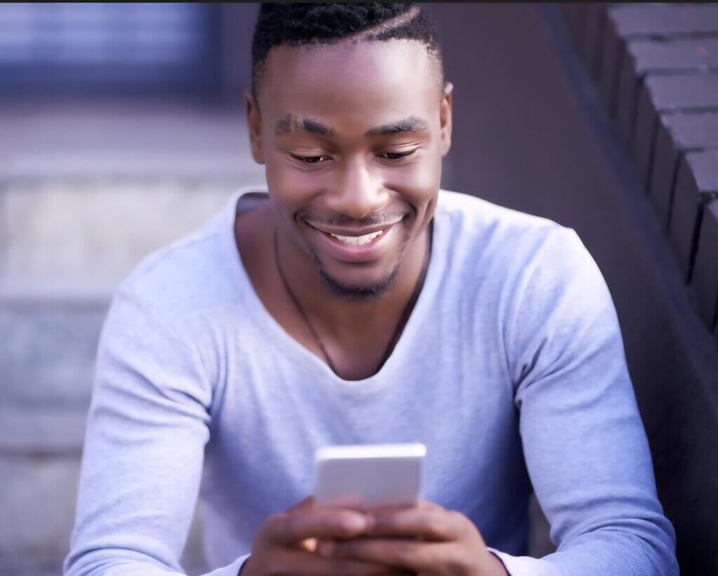A man smiles after receiving a Heartfelt Love SMS