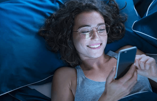 una ragazza è felice di vedere il messaggio di testo dal telefono