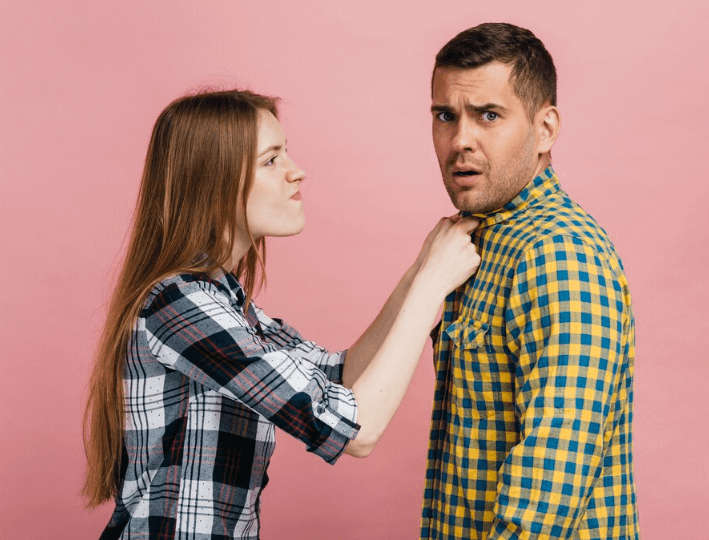 Medium shot angry woman holding her friend's shirt